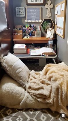 an unmade bed with blankets on it in front of a desk and bookshelf