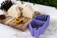 three plastic containers sitting on top of a wooden board next to pine cones and flowers