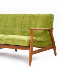 a green couch sitting on top of a wooden frame