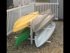 two surfboards are sitting on top of each other in front of a white fence