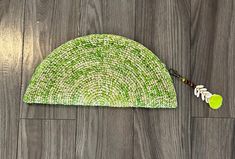 a green hat sitting on top of a wooden floor next to a white and black object