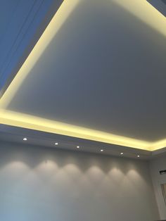 an empty room with white walls and lights on the ceiling is pictured in this image