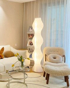 a living room filled with furniture and a tall white vase on top of a table