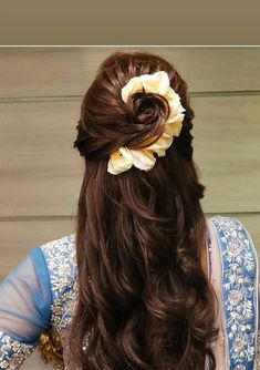 a woman with long brown hair wearing a flower in her hair