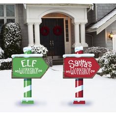 two christmas yard signs in front of a house