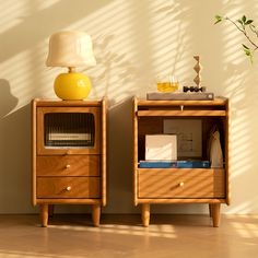 two wooden nightstands side by side against a white wall with a lamp on top