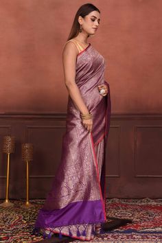 Radiate elegance on festive occasions in this stunning purple Katan silk Banarasi sari with zari work. The saree has a red edging. It comes with a matching blouse piece. Disclaimer: The shown stitched blouse on the model is for display purpose only. The saree comes with a matching blouse piece and finished with fall and piko. Disclaimer: The actual product may vary slightly from the image. These are custom orders, hence expect slight variation in color, placement of the motif or buta. ESTIMATED Silk Sarees Kanchipuram, Banarasi Sari, Silk Banarasi Saree, Tussar Silk Sarees, Indian Clothing Store, Latest Designer Sarees, Fashion Journals, Katan Silk, Tussar Silk Saree