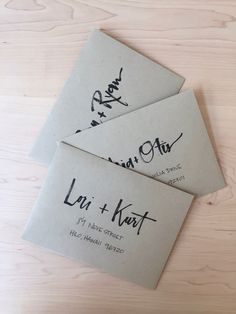 two envelopes with writing on them sitting on a table