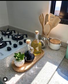 a kitchen counter with cooking utensils and bottles on it next to a stove