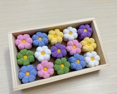 small colorful flowers in a wooden box on a table