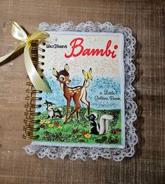 a book with an image of a deer and other animals on the cover is tied to a lace doily