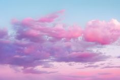 the sky is filled with pink clouds and blue water