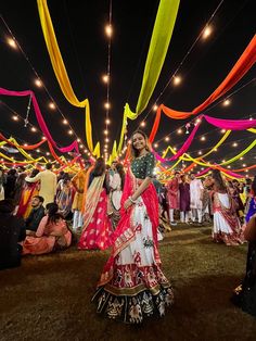 a woman in a red and white lehenga dancing with other people around her