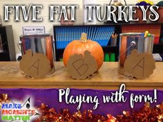 three pumpkins sitting on top of a table next to two tin cans with hearts drawn on them