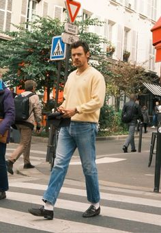 a man walking across a cross walk in the street