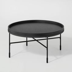 a round table with black metal legs and a black tray on the top that has a dark gray surface