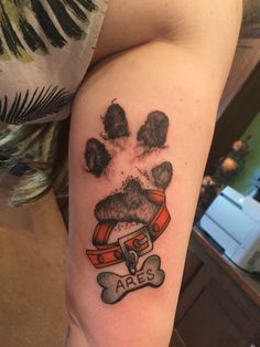 a person with a tattoo on their arm that has a dog's paw and chest