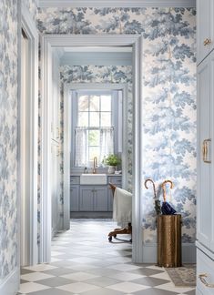 an open door leading to a bathroom with blue and white wallpaper