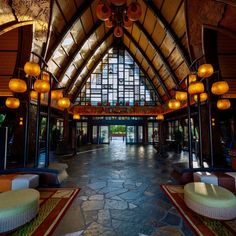 the inside of a large building with lots of lights hanging from it's ceiling