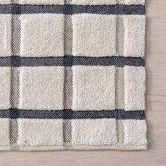 a black and white checkered rug on top of a wooden floor