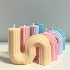 four candles with the letter u in different colors