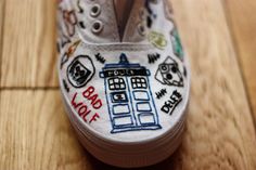 a pair of white shoes with doctor who themed painted on the soles are sitting on a wooden floor