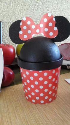 a minnie mouse cup sitting on top of a wooden table