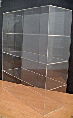 a clear acrylic display case sitting on top of a wooden table