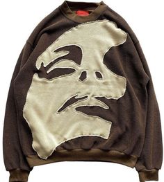 a brown sweatshirt with a face drawn on the front and back, sitting against a white background