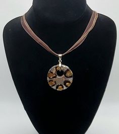 Beautiful vintage art glass round pendant with silver tone metal bail on a necklace of ribbon and leather cords, and an extension chain. 18 inches long, with a 2 inch extension chain 2 1/2 x 1 3/4 inch pendant 23g total UNMARKED Brown Necklace With Large Round Pendant, Brown Necklace With Adjustable Cord And Round Pendant, Adjustable Brown Medallion Necklace, Artistic Adjustable Brown Necklace, Adjustable Glass Round Pendant Necklace, Adjustable Brown Artistic Necklace, Artistic Brown Necklace For Gift, Brown Glass Necklace For Gift, Warwick Ny