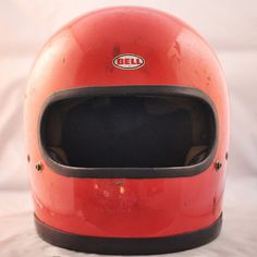 an old red bell motorcycle helmet on a white background