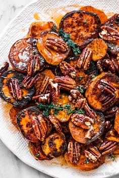 a white plate topped with sweet potatoes and pecans