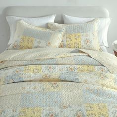 a white bed with yellow and blue bedspread