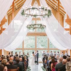 a bride and groom standing at the end of their wedding ceremony in an open barn