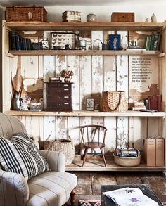 a living room filled with furniture and lots of books on top of a wooden shelf