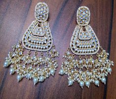 Metal = Gold Plated Occasion = Wedding ,Party Wear, Bridal Color = White and Yellow Size = Earrings Size - 4 Inches(approx) Closure = Screw Back Weight = 35 gram each Earring 100% Satisfaction Guarantee: 1 Year Warranty, Long Lasting Plating, High-Quality Stones Occasion: Perfect choice for any Indian occasion. Care: It is advisable that you keep products away from direct heat, humidity, and moisture. It is best to preserve your jewelry in the box. Keep Away From Water, Spray, And Perfumes For B Traditional White Pearl Earrings For Reception, Heavy White Danglers For Celebration, White Meenakari Pearl Earrings For Weddings, White Temple Jewelry Chandelier Earrings For Celebration, White Bollywood Earrings For Reception, Bollywood White Earrings For Reception, Bollywood Style White Earrings For Reception, White Latkan Bridal Earrings For Reception, Heavy White Chandelier Earrings For Festive Occasions