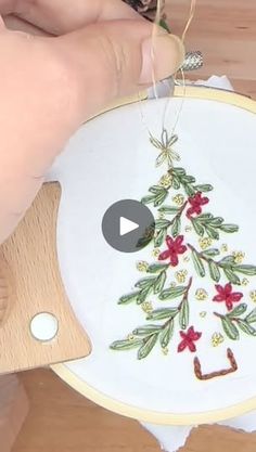 someone is stitching a christmas tree ornament on a white plate