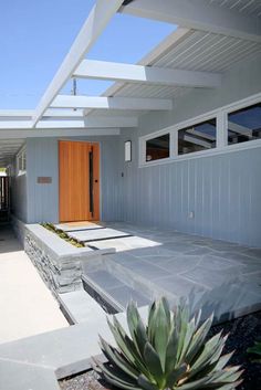 a house with a wooden door and white walls