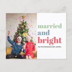 a christmas card with two people sitting in front of a tree and confetti