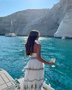 a woman in a white dress standing on a boat