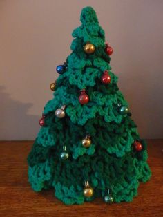 a crocheted christmas tree on a wooden table