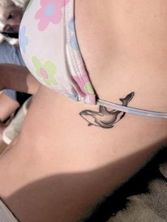 a woman's stomach with a bird tattoo on her belly and the bottom part of her panties