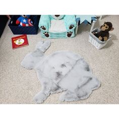 a stuffed elephant laying on the floor next to a teddy bear and other toy items