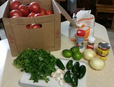 some vegetables are sitting on a table next to a box of tomatoes and other ingredients