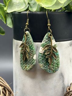 Large Statement Earrings- Beautifully handmade earrings from polymer clay and high-quality hypoallergenic antique bronze zinc alloy, which is durable, sturdy, lightweight, and comfortable enough for all-day wear. Our Clover earrings are greens, white and gold marbling with a beautiful antique bronze leaf charm that are created to make you feel confident and beautiful. Our cute earrings are perfect for women and young girls of all ages.  Perfect for daily wear, date night, and special occasions. Green Brass Earrings Nature-inspired, Handmade Nature-inspired Resin Earrings, Elegant Green Patina Earrings, Nature-inspired Handmade Resin Earrings, Earthy Green Dangle Earrings, Earthy Green Drop Earrings, Green Brass Earrings As Gift, Green Brass Earrings For Gift, Green Copper Earrings For Gift