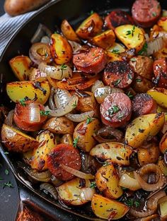 a pan filled with potatoes and sausages on top of a table