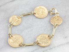 We've crafted this unique bracelet out of antique coins! On the back of the coins are ornate monogram signets, giving this piece a fabulous pattern! This is a "go with everything" bracelet that could be worn by either a man or woman! Metal: 18K/10K Yellow Gold, 90% Gold Coin Width: 18 mm Length: 7.25 inches Marks: "10K" Stamped on the Bracelet Gold Link Bracelet, Platinum Wedding Band, Antique Coins, Platinum Wedding, Purple Sapphire, Gold Link, Gold Coin, Unique Bracelets, Strand Bracelet