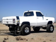 a white truck parked on top of a dirt field