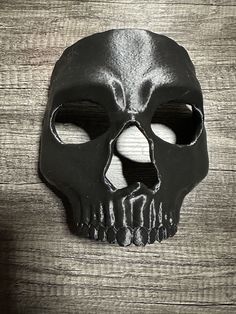 a black skull mask on top of a wooden table