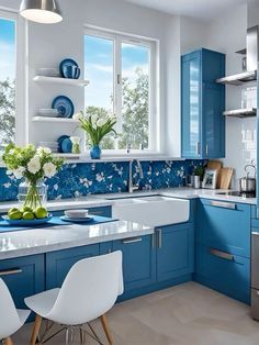 a blue and white kitchen with lots of counter space in the center, along with two chairs